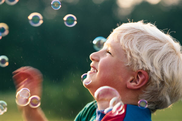 child blowing bubbles